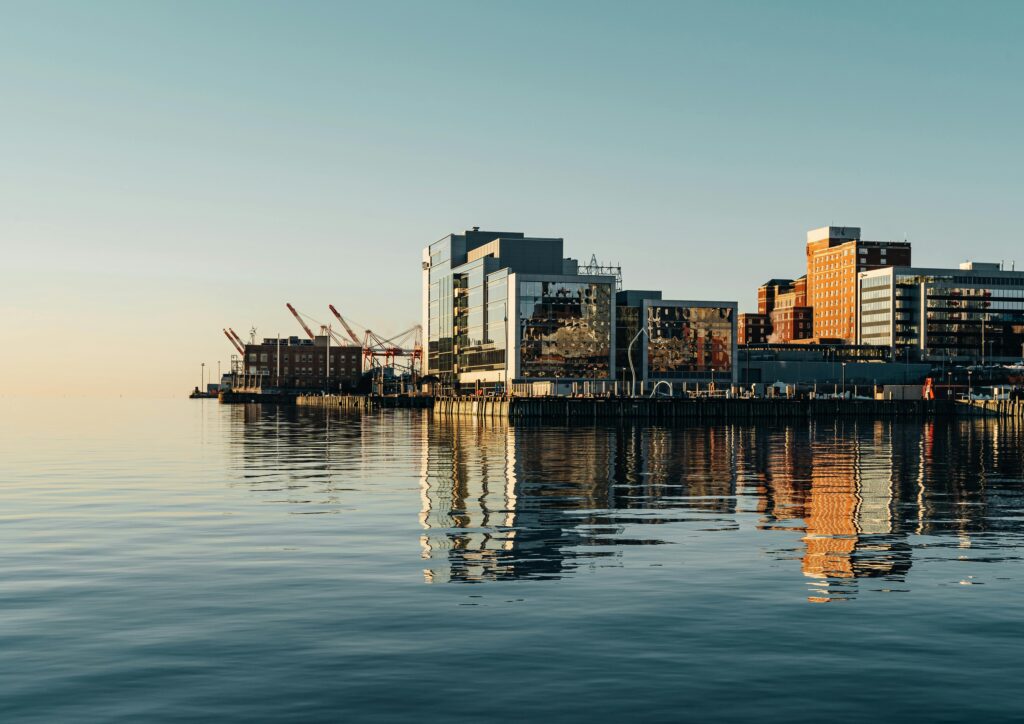 Understanding Consular Services A serene view of Halifax waterfront with modern buildings reflecting on the water under a clear sky.