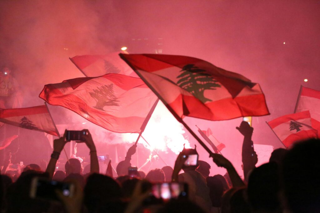 Vibrant night festival in Beirut with people waving Lebanese flags, capturing a moment of unity.