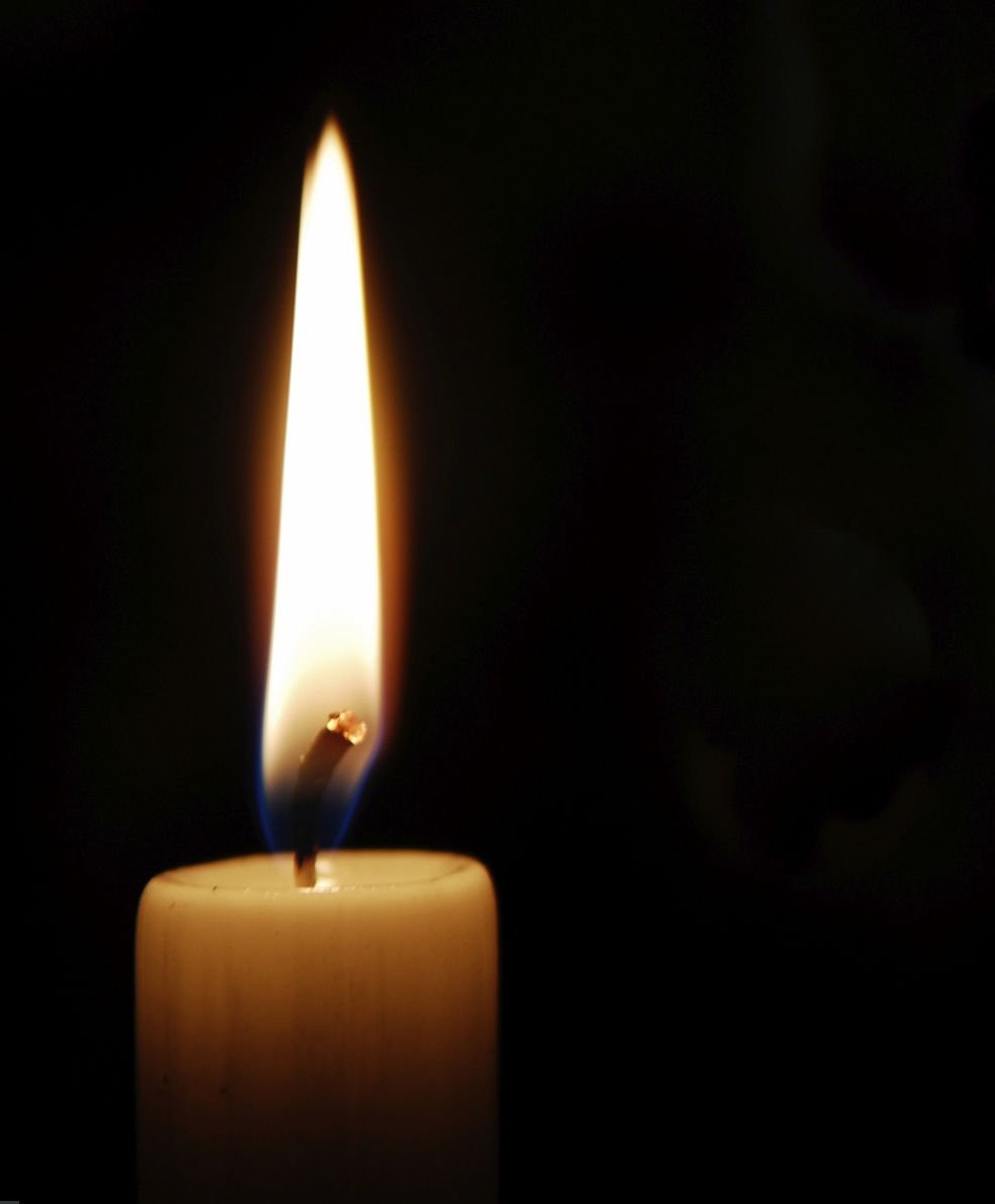 white candle burning in the dark